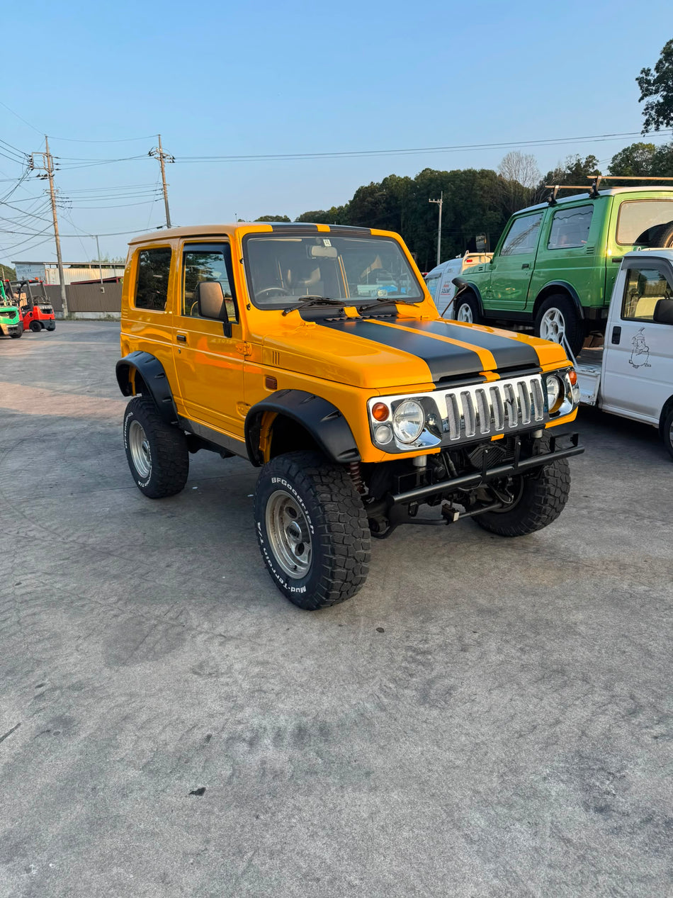Yellow and black 1997 Suzuki Jimny Sierra 4x4 kei SUV
